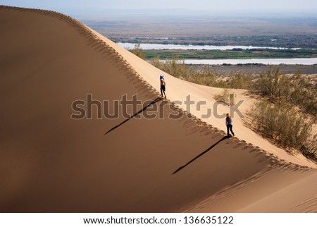National park Altyn Emel. Kazakhstan. Two people on the top of a sand dune