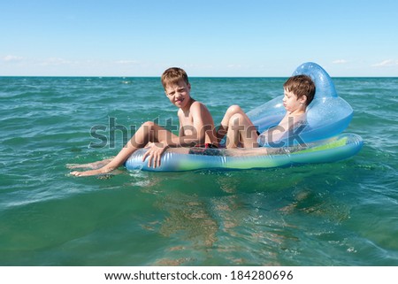 Two brothers swimming in inflatable boat