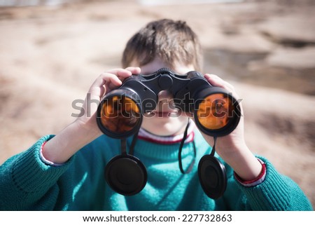 Little boy looking forward with binoculars