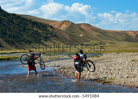 Two mountain bikers and mountain river