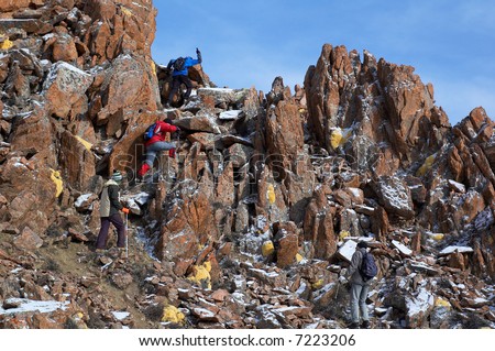 High mountains treking group climbing to cliff