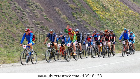Mountain bikers group racing on road in desert