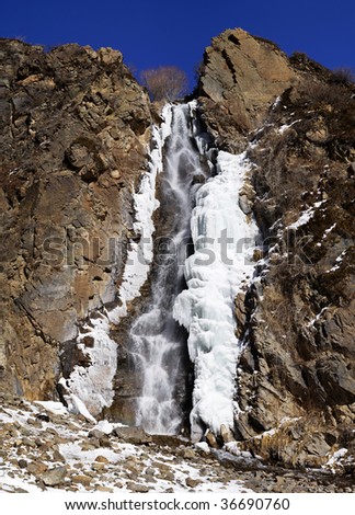 Waterfall, ice, rock and blue sky (vertical assembly of the two images)