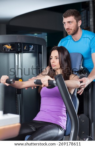 the girl with the coach is engaged in the gym