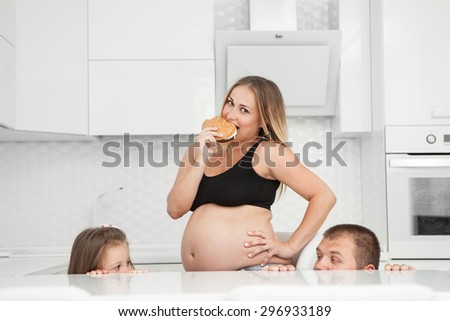Pregnant eats a hamburger