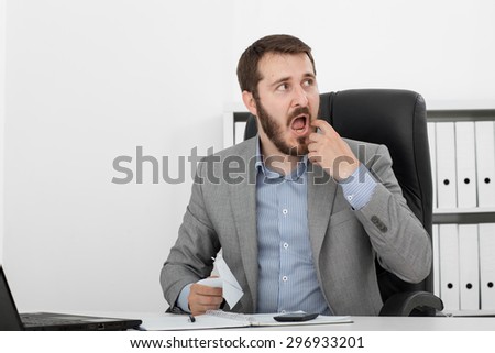 happy man businessman at his desk makes a paper airplane