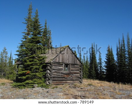 An old log cabin sits on top of a mountain in Montana