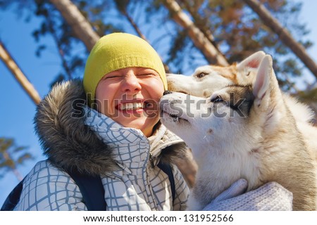 young woman emracing sled dogs