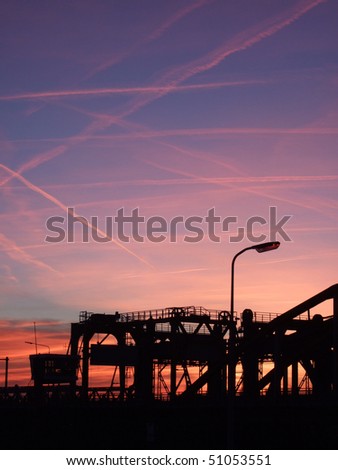 Many red contrails over an industrial scene