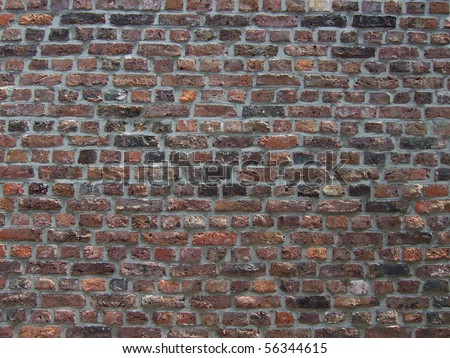 Part of a dark red brick wall