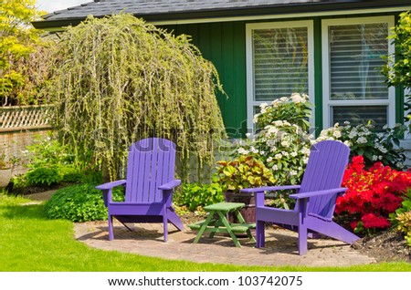 Colorful wooden lawn chairs at the front ( back ) yard.