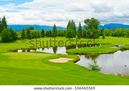 Golf course with gorgeous green and pond.