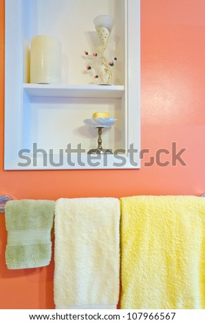 Fragment of a luxury bathroom with three towels on a hanger