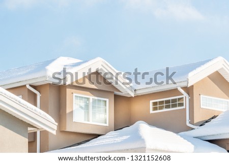 A perfect neighbourhood. Houses in suburb at Winter in the north America. Fragment of a luxury house covered nice snow.