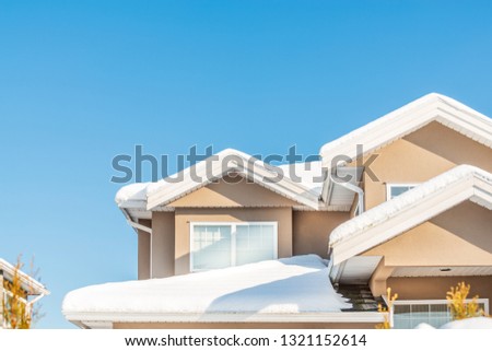 A perfect neighbourhood. Houses in suburb at Winter in the north America. Fragment of a luxury house covered nice snow.