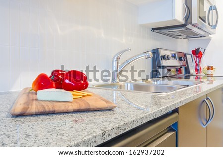 interior of small white kitchen with red pepper on the table