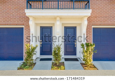 Entrance of a house. Double door with two garage doors.