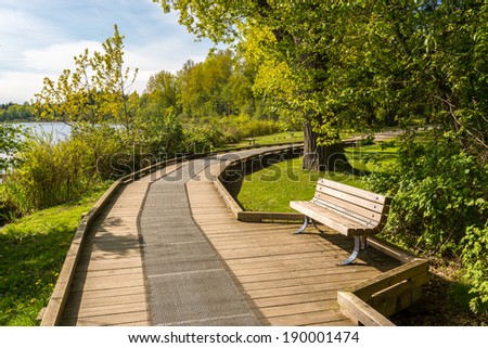 Trail and picnic bench in Deer Lake Park, Vancouver, Canada.