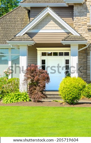 A very clean entrance of a house with a nice lawn and outdoor landscape