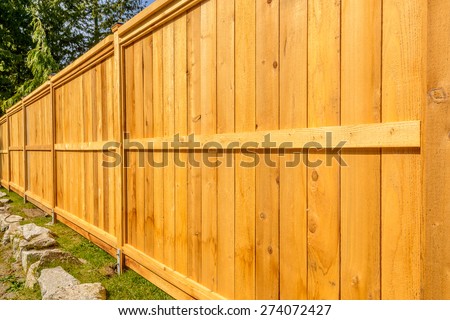 wooden fence with green lawn and houses