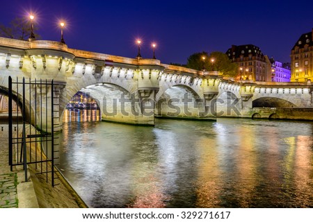 Paris bridge and Seine river at night.