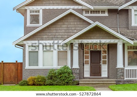 A perfect neighborhood. Houses in suburb at Fall in the north America. Fragment of a luxury house with entrance door and nice window.
