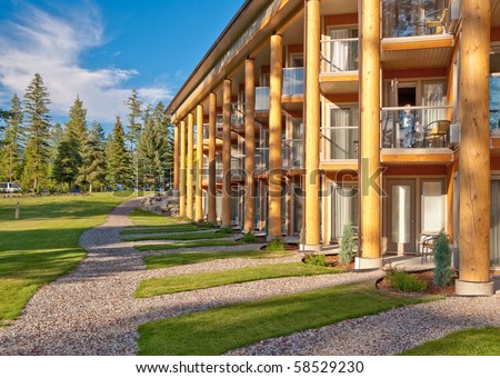 Wooden resort building over trees and gravel paths.