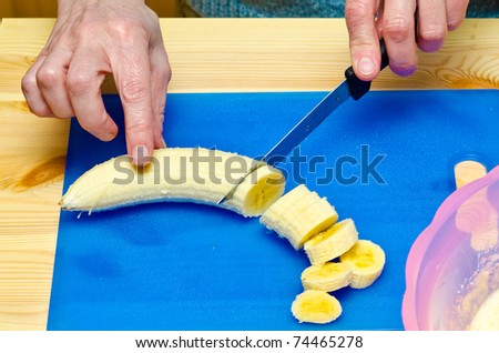 Making cookies. The cook has cut apple and starts to cut banana.