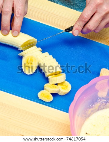 Making cookies. The cook has cut apple and starts to cut banana.