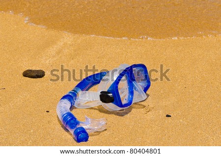 Diving mask and snorkel on gold sand.