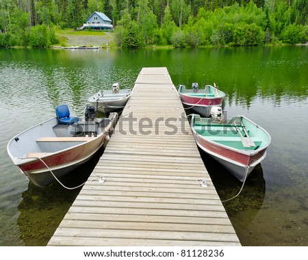 Boats on lake over a waterfront house.