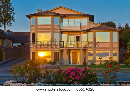 Luxury house at dusk with gorgeous reflections in windows in Vancouver, Canada.