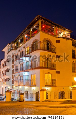 Nice hotel building with roof restaurant at night in Puerto Vallarta, Mexico.