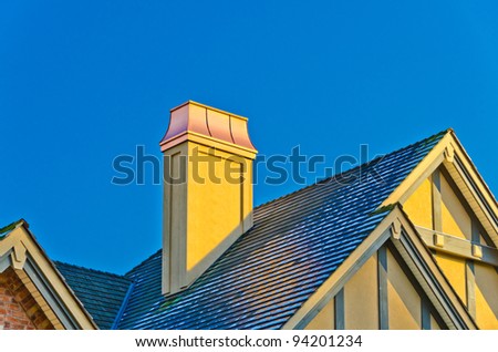 the roof of the house with nice chimney under the blue sky