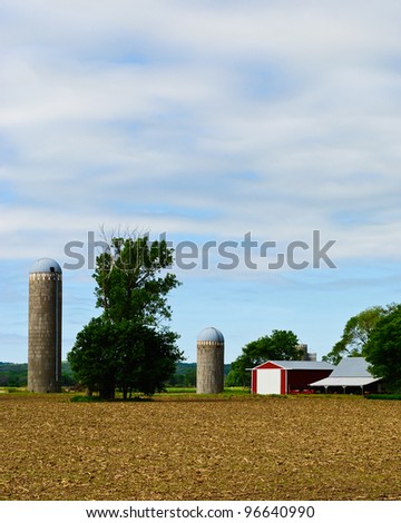Barn, Field and Silos Against a Blue Sky on a Midwestern Farm