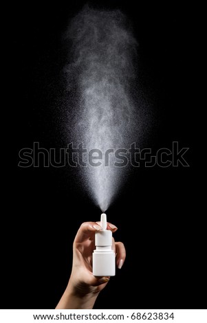 Nasal spray bottle photographed while spraying, motion blur.