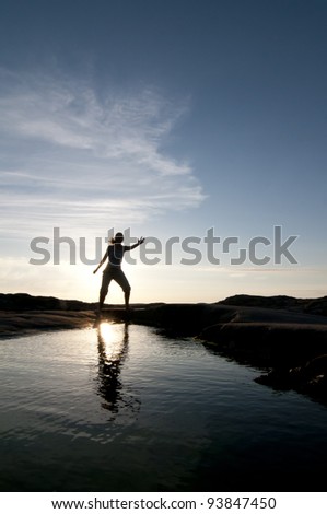 female silhouette pose reflected in water