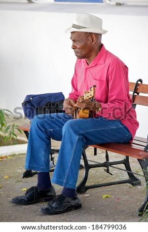 PANAMA CITY, PANAMA - JANUARY 18, 2014: An old musician playing for money in an  open air market in Casco Viejo in Panama City Panama. Casco Viejo was designated a World Heritage Site in 1997.