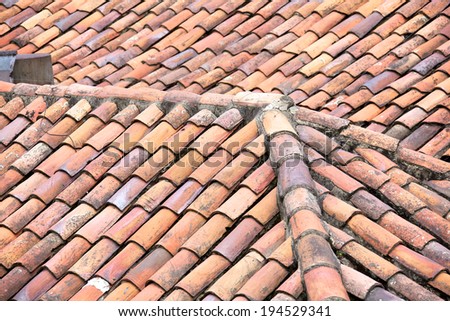 Close up of old and weathered red roof tiles