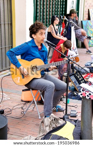 BOGOTA, COLOMBIA - APRIL 06, 2014: An unidentified musician playing guitar for money in the streets of Usaquen in Bogota Colombia. Usaquen was declared a national monument in 1987.