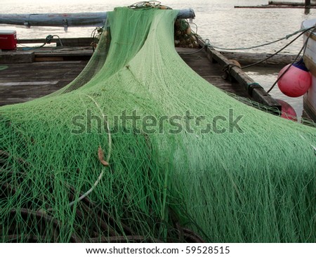 A large commercial fishing net set out to dry on a dock in the Fraser River