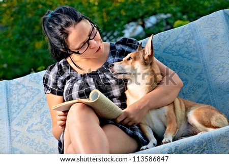 pretty young woman with dog reading magazine