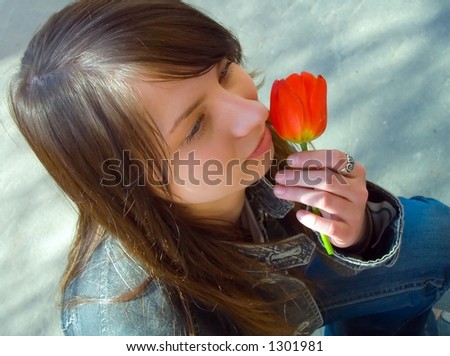 The girl with a flower on a background of asphalt