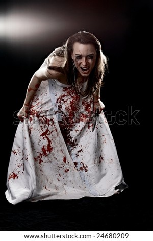 crazy woman in gown with blood with knife on black background