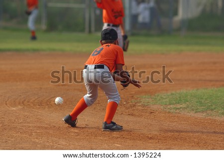 Baseball player lining up to catch a ball in play.