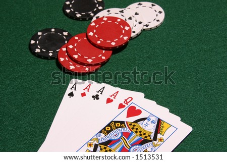 Four aces and queen of hearts on pker table with chips in background, selective focus image.