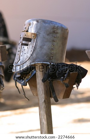 Knights helmet at rest on a wood stake.