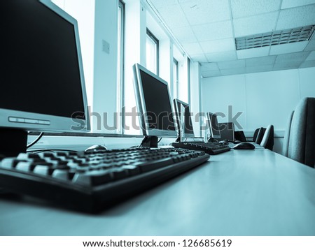 Computers in an office with light from windows.