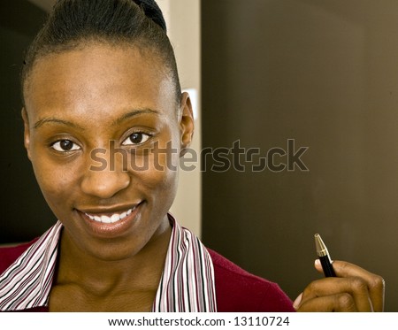 An attractive African American office worker, business woman or  student prepared to take notes.