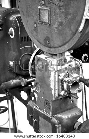 A vintage movie projector from an abandoned movie theater photographed in black and white.